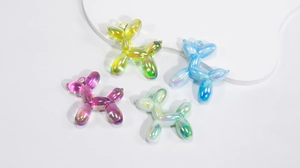 Macro view of colorful aurora acrylic balloon dog charms for DIY jewelry and crafts