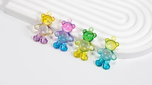 Macro detail of four colorful translucent gradient acrylic bear charms for DIY jewelry making