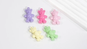 Close-up of five colorful acrylic bear pendants for DIY jewelry and keychain making
