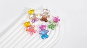 Macro detail of five colorful transparent gradient resin bear charms for DIY jewelry making