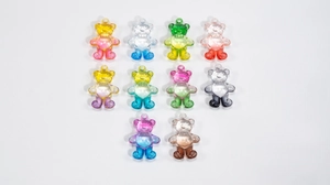 Macro view of ten colorful gradient acrylic bear charms for DIY jewelry and keychains