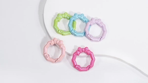 Dettaglio di cinque fermagli a molla a forma di fiocco perlato in colori pastello assortiti
