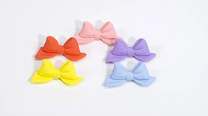 Five matte colorful acrylic bow beads in pink, orange, purple, yellow, and light blue