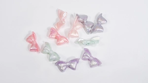 Macro detail of colorful bow-shaped acrylic beads with a pearlescent finish for DIY crafts