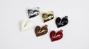 Dettaglio di ciondoli a cuore in argento, oro e lacca per la creazione di gioielli DIY