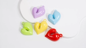 Dettaglio di ciondoli a cuore in acrilico colorato per la creazione di gioielli fai da te