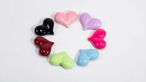 Vista dettagliata di perle in acrilico colorate a forma di cuore per gioielli DIY