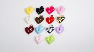 Vista piatta di 14 ciondoli a cuore 3D colorati in acrilico con anelli per gioielli DIY