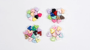 Nahaufnahme von herzförmigen bunten Harzperlen für DIY-Schmuck in verschiedenen Stilen