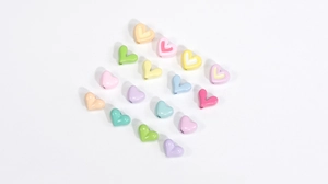 Makroansicht von herzförmigen Acrylperlen in Macaron-Farben für DIY-Schmuck