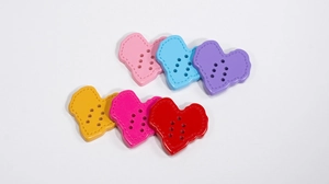 Close-up of colorful heart-shaped acrylic buttons with decorative dashed edges and six holes