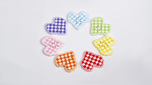 Detailed view of heart-shaped checkerboard acrylic buttons for DIY crafts and jewelry