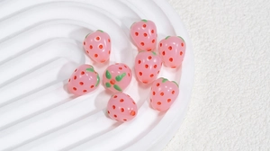 Makroaufnahme von rosa Erdbeerperlen für DIY-Schmuck und handgefertigtes Zubehör