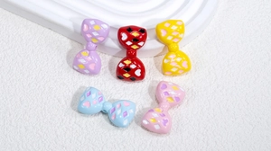Vista macro de cuentas de lazo acrílicas de colores con corazones para joyería DIY