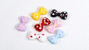 Primer plano de cuentas acrílicas de lazos coloridos para joyería DIY con corazones