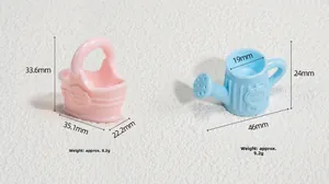 Detailed macro view of pink floral basket and blue watering can charms with dimensions