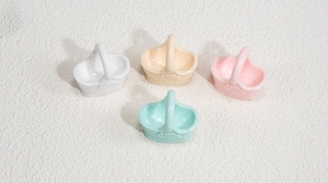 Détail de mini pendentifs paniers en acrylique colorés en blanc, crème, rose et menthe