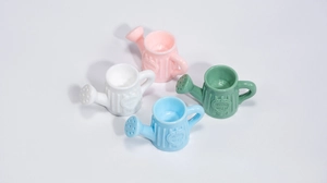 Gros plan de mini arrosoirs colorés avec motif de cœur pour accessoires de bricolage