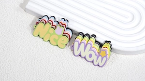 Nahaufnahme bunter WOW und NICE Anhänger mit Tropföl-Finish und süßen Kaninchen-Details
