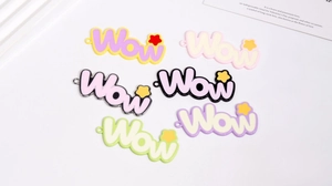 Nahaufnahme von bunten 'Wow' Legierungsanhängern für DIY-Schmuck und Schlüsselanhänger