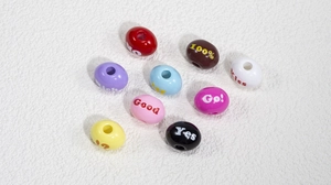 Makroaufnahme bunter Acryl-Alphabetperlen mit graviertem Text für DIY-Schmuckherstellung