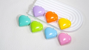 Nahaufnahme bunter Herzanhänger aus Acryl in hellen Bonbonfarben für DIY-Schmuck