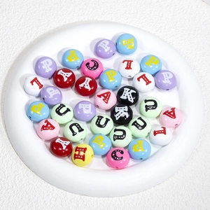 Bunte runde Acryl-Buchstabenperlen in einer weißen Schale für DIY-Schmuck und Bastelarbeiten