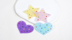 Dettaglio di ciondoli colorati in acrilico a forma di stella e cuore per gioielli fai-da-te