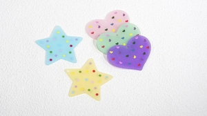 Dettaglio di ciondoli in acrilico colorato a forma di stella e cuore per gioielli fai da te
