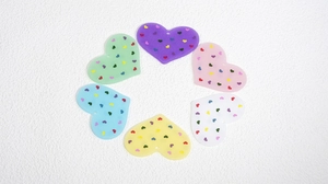 Dettaglio dei ciondoli a cuore in acrilico con piccoli motivi di cuori colorati