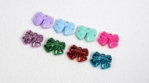 Detailed view of colorful bow charms with hanging holes for DIY jewelry making crafts