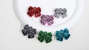 Close-up of metallic bow charms in six vibrant colors for DIY jewelry making and crafts