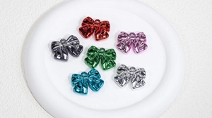 Macro detail of six colorful metallic bow charms with top rings for DIY jewelry