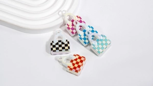 Macro view of iridescent checkered handbag charms in various vibrant aurora gradient colors
