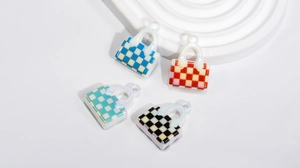 Detailed view of colorful acrylic checkered handbag charms in blue, red, and green patterns