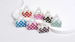 Macro view of iridescent acrylic checkered handbag pendants for DIY jewelry and keychains