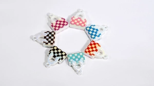 Detail of colorful acrylic checkerboard purse charms with glossy pearlescent finish