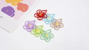 Vue détaillée de breloques fleurs en alliage avec pétale creux et symbole du dollar