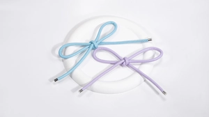 Close-up of sky blue and lavender PU leather bow charms with elegant silver metal tips