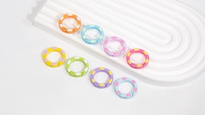Gros plan sur des anneaux à ressort colorés en émail style bambou et connecteurs en alliage