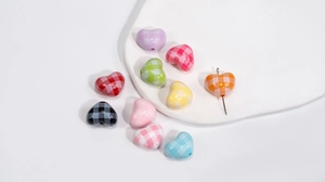 Macro shot of colorful checkered acrylic heart beads with center holes for DIY jewelry