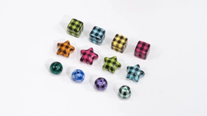 Detailed view of colorful checkerboard acrylic beads in various geometric shapes for DIY crafts