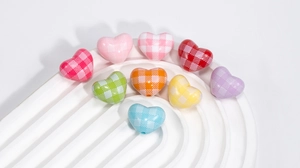 Macro detail of heart-shaped acrylic beads with classic checkered pattern for DIY jewelry