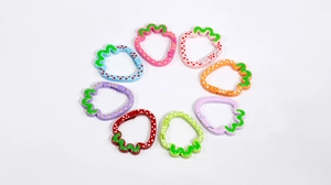 Macro view of eight colorful strawberry-shaped alloy spring rings for DIY keychains