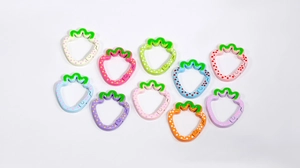 Close-up of strawberry-shaped alloy spring rings in colorful painted finishes for DIY crafts