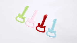 Macro detail van kleurrijke gitaarvormige flesopener sleutelhangers met gravering