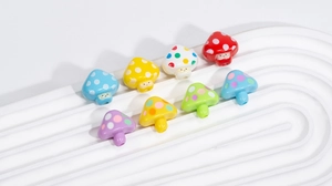Detailed view of colorful acrylic mushroom beads with polka dots and smiling faces for DIY