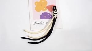 Detailed view of bicolor spiral knot phone lanyard strap with black and white braided cords