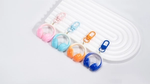 Détail de porte-clés casque en acrylique dégradé coloré avec fermoirs mousqueton assortis