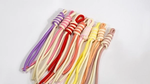 Detail of colorful braided spiral knot wrist lanyards with various vibrant color patterns